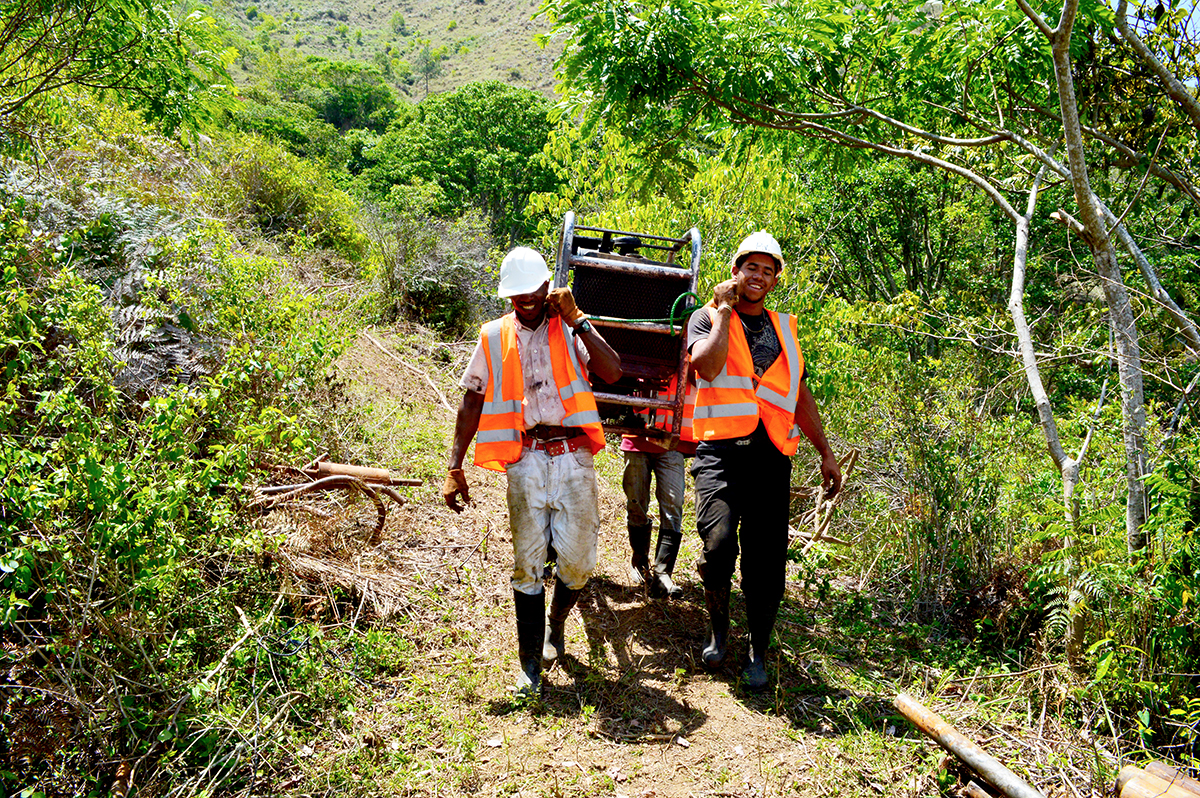 GoldQuest local drillers carrying a man-portable drill 