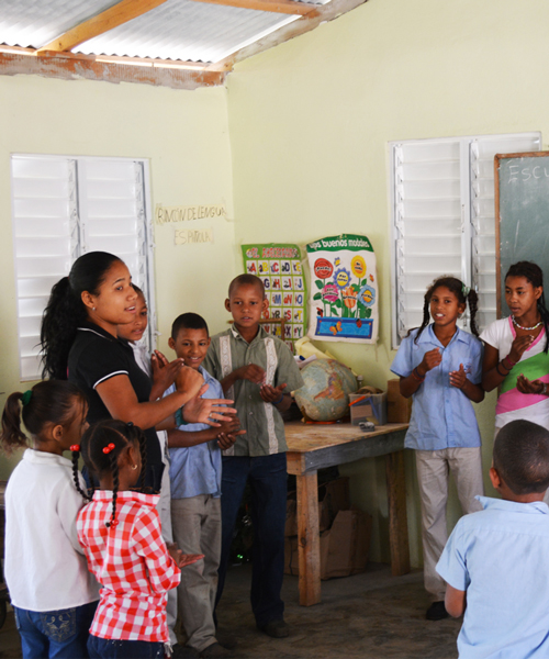 Teacher and students in the first primary school built in Hondo Valle (school built by GoldQuest)