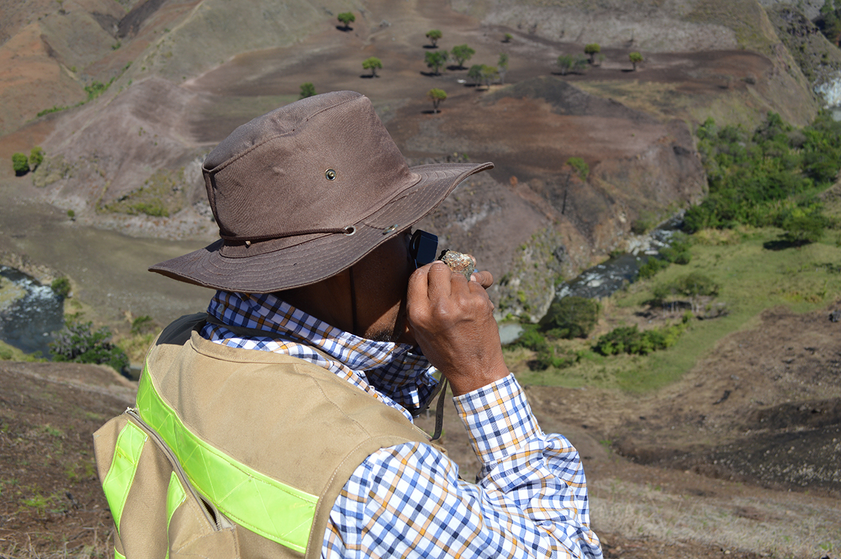 Geologist, Amarante, looking at an outcrop sample in the field